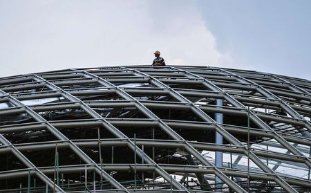 © Reuters. A labourer looks out from atop a construction site in Guangzhou