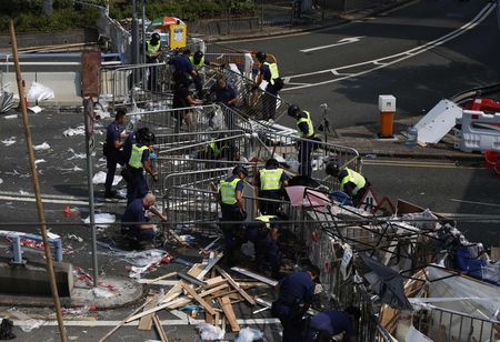 © Reuters. Los policías de Hong Kong quitan barricadas de las protestas