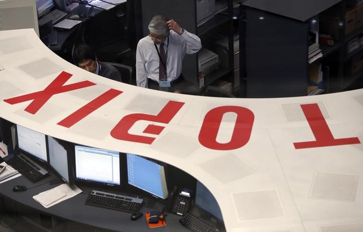 &copy; Reuters Employees of the Tokyo Stock Exchange (TSE) look at a monitor at the bourse at the TSE in Tokyo