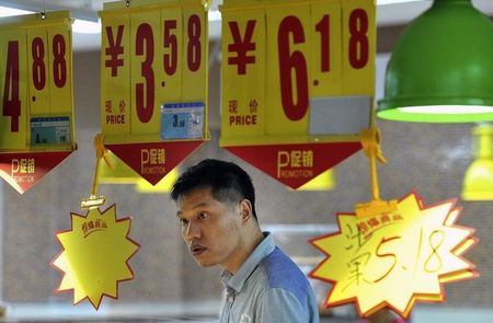 © Reuters. A man looks at a price tag as he shops at a supermarket in Hefei