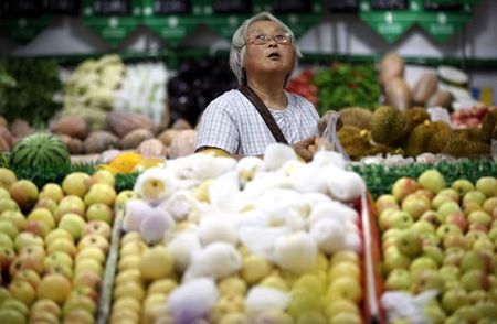 © Reuters. Una signora in un mercato di frutta in un villaggio nei pressi di Pechino 