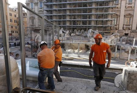 © Reuters. Workers prepare a specially built footbridge for tourists, at the Trevi fountain in Rome