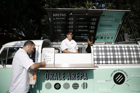 © Reuters. Venezuelan chef Jorge Udelman prepares to serve Venezuelan food on his food truck at a parking lot in Mexico City