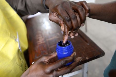 © Reuters. A voter's finger is marked after voting in the general election in Maputo