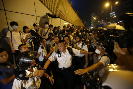 © Reuters. Polícia em retirada após confrontos com manifestantes pró-democracia perto da sede do governo em Hong Kong