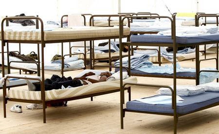 © Reuters. File photo of asylum seekers resting on bunk beds at a refugee tent camp called 'The Tent' in Munich 