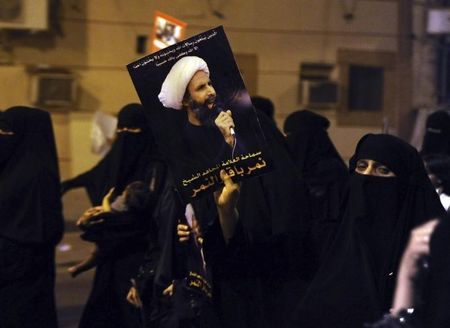 © Reuters. Manifestante ergue fotografia do xeique Nimr al-Nimr durante um protesto na cidade litorânia de Qatif, na Arábia Saudita