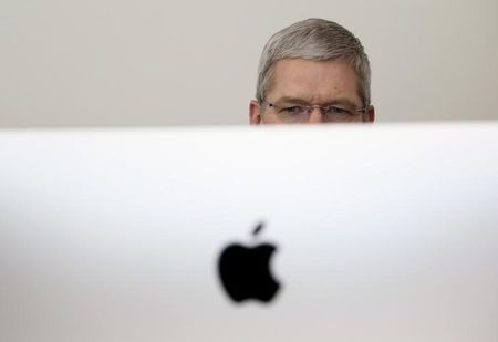 © Reuters. Apple CEO Tim Cook looks at a new IMac after presentation at Apple headquarters in Cupertino