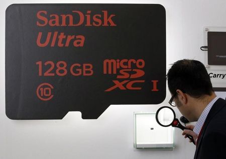 © Reuters. A visitor looks at a SanDisk microSD card at the Mobile World Congress in Barcelona