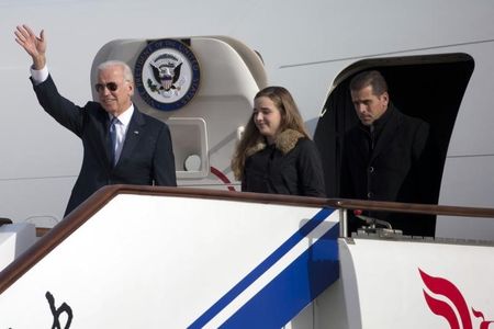 © Reuters. U.S. Vice President Biden waves as he walks out of Air Force Two with his granddaughter Biden and son Biden at the airport in Beijing