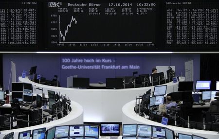 © Reuters. Traders are pictured at their desks in front of the DAX board at the Frankfurt stock exchange