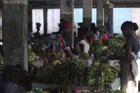 © Reuters. Mulher vende verduras em mercado de Monróvia