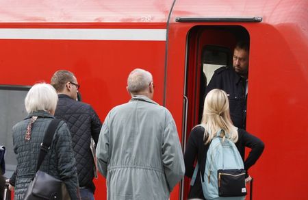 © Reuters. Passengers ask for information from a train driver of German railways, Deutsche Bahn (DB) at the railways station of the Cologne-Bonn airport