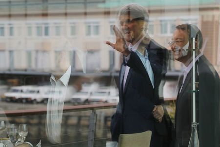 © Reuters. United States Secretary of State John Kerry and China's State Councillor Yang Jiechi are reflected in window in Boston