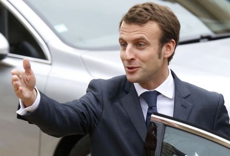 © Reuters. French Economy Minister Emmanuel Macron gestures as he enters a Peugeot 308 car after the weekly cabinet meeting at the Elysee Palace in Paris