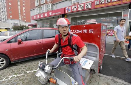 © Reuters. Liu, CEO and founder of China's e-commerce company JD.com, rides an electric tricycle as he leaves a delivery station in Beijing