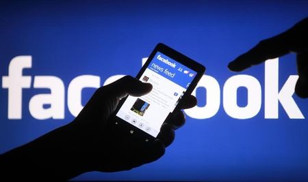 © Reuters. A smartphone user shows the Facebook application on his phone in Zenica, in this photo illustration