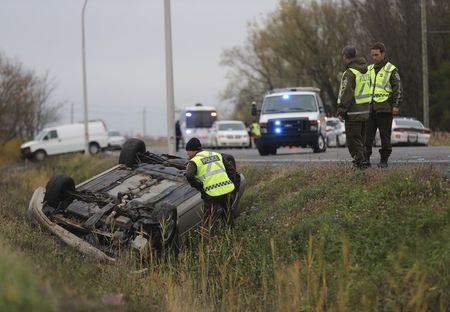 © Reuters. Surete du Quebec officer investigates an overturned vehicle in Saint-Jean-sur-Richelieu