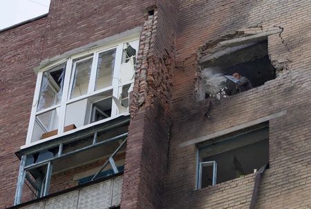 © Reuters. Homem remove escombros de um apartamento atingindo por bombardeios em Donetsk, no lesta da Ucrânia 