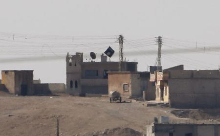 © Reuters. A black flag belonging to the Islamic State is seen in the Syrian town of Kobani, as pictured from the Turkish-Syrian border near the southeastern town of Suruc