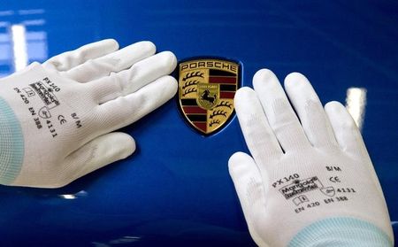 © Reuters. A man does the final touches on the Porsche logo of a Macan at the new plant in the eastern German city of Leipzig