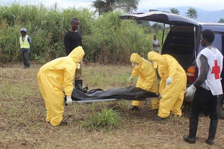 © Reuters. Funcionários de serviços de saúde carregam corpo de vítima com Ebola no distrito de Waterloo,  Freetown