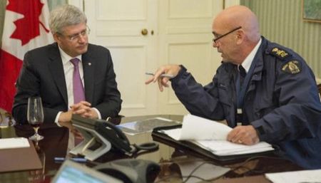 © Reuters. Canadian Prime Minister Stephen Harper is briefed by Royal Canadian Mounted Police (RCMP) commissioner Bob Paulson following a shooting incident on Parliament Hill in Ottawa in this handout photo