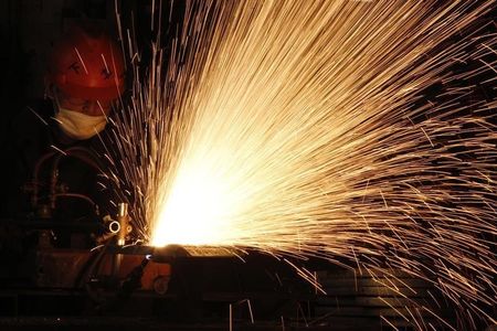 © Reuters. A worker cuts a steel plate at a workshop of the Electro-Mechanical Equipment Co, Ltd. in Huaibei