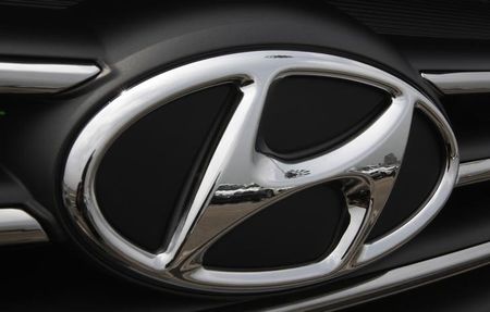 © Reuters. Kia cars are reflected in the Hyundai auto logo at a shipping yard in Pyeongtaek