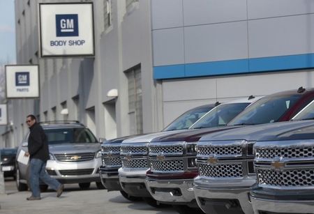 © Reuters. A man walks past a row of General Motors vehicles at a Chevrolet dealership on Woodward Avenue in Detroit, Michigan