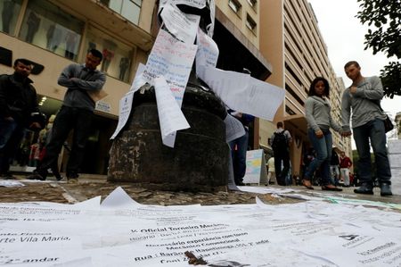© Reuters. Pessoas olham lista de vagas de emprego em rua no centro de São Paulo