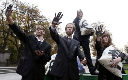 © Reuters. Ativistas ambientais protestam vestidos de lobistas com as mãos sujas de carvão em Bruxelas