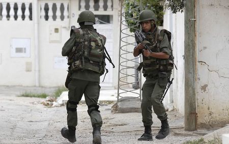 © Reuters. Tunisian soldiers surround a house in Oued Ellil, west of Tunis after heavy exchanges of gunfire in Tunis