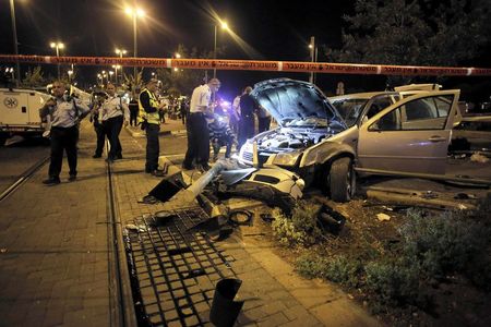 © Reuters. Israeli policemen inspect a car wreck in Jerusalem