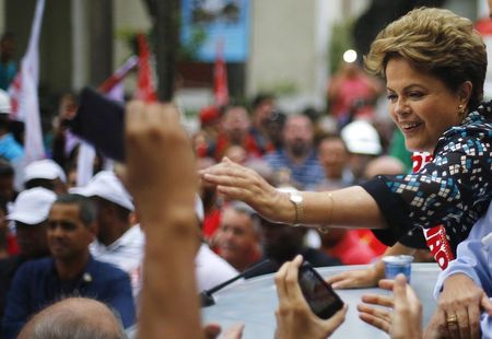 © Reuters. Brazil's President and Workers' Party (PT) presidential candidate Dilma Rousseff (R) greets her supporters during a campaign rally in Duque de Caxias near Rio de Janeiro