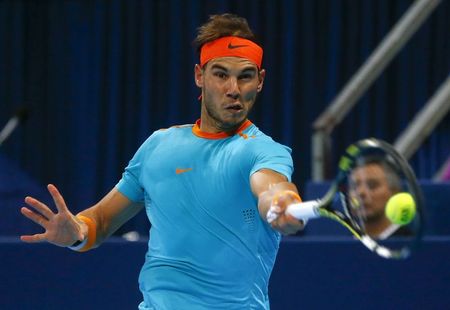 © Reuters. Nadal of Spain returns the ball during his match against France's Herbert at the Swiss Indoors ATP tennis tournament in Basel