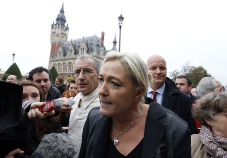 © Reuters. Marine Le Pen , France's National Front political party head, speaks to journalists as she walks near the town hall in Calais