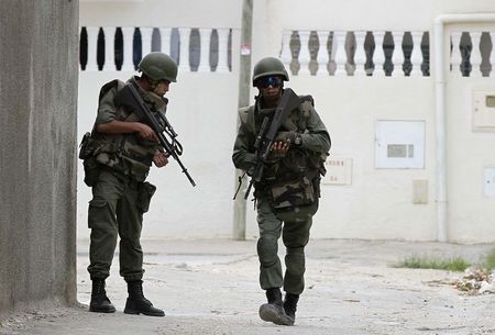 © Reuters. Tunisian soldiers patrol a residence in Oued Ellil, west of Tunis