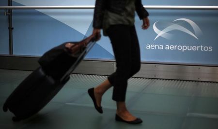 © Reuters. A passenger carries her belongings at Madrid's Barajas airport