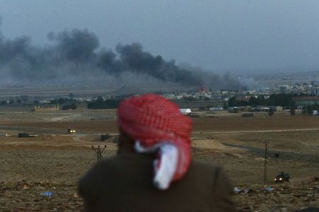 © Reuters. Turco curdo observa cidade de Kobani sendo alvejada