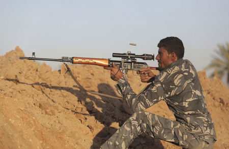 © Reuters. A Shi'ite fighter aims using a sniper rifle during a patrol in Jurf al-Sakhar
