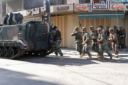 © Reuters. Lebanese army soldiers march behind a tank during clashes with Islamists in Tripoli