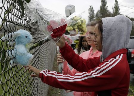 © Reuters. Student Tyanna Davis and others place flowers outside Marysville-Pilchuck High School the day after a shooting at the school in Marysville, Washington