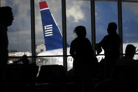 © Reuters. People wait for a US Airways flight to depart for North Carolina from Miami International Airport in Miami