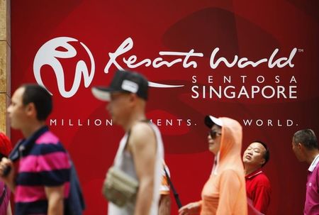 © Reuters. People walk past a logo of Genting Singapore's Resorts World Sentosa in Singapore