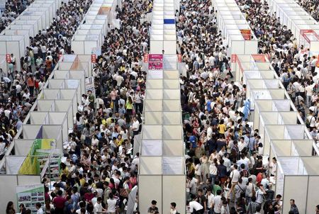 © Reuters. Thousands of job seekers visit booths at a job fair in Chongqing municipality