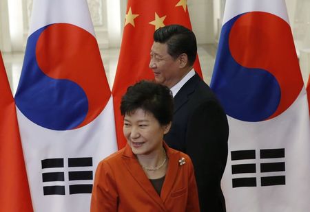 © Reuters. South Korea's President Park walks next to China's President Xi in front of Chinese and South Korean national flags during a meeting at the Great Hall of the People, on the sidelines of the Asia Pacific Economic Cooperation (APEC) meetings, in B