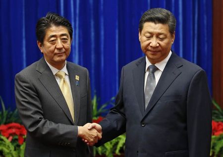 © Reuters. China's President Xi Jinping shakes hands with Japan's Prime Minister Shinzo Abe during their meeting on the sidelines of the APEC meetings in Beijing