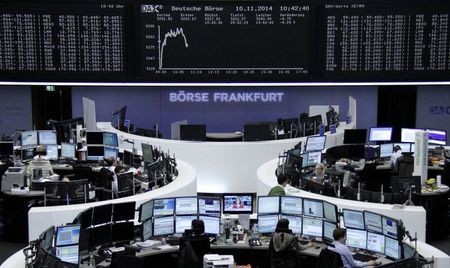 © Reuters. Traders are pictured at their desks in front of the DAX board at the Frankfurt stock exchange