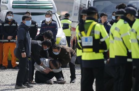 © Reuters. A family member of missing passengers cries next to a a temporary morgue at a port in Jindo